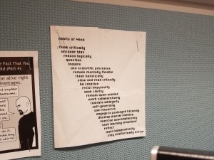 Photo of a list on slightly rumpled white paper, stapled to a bulletin board.